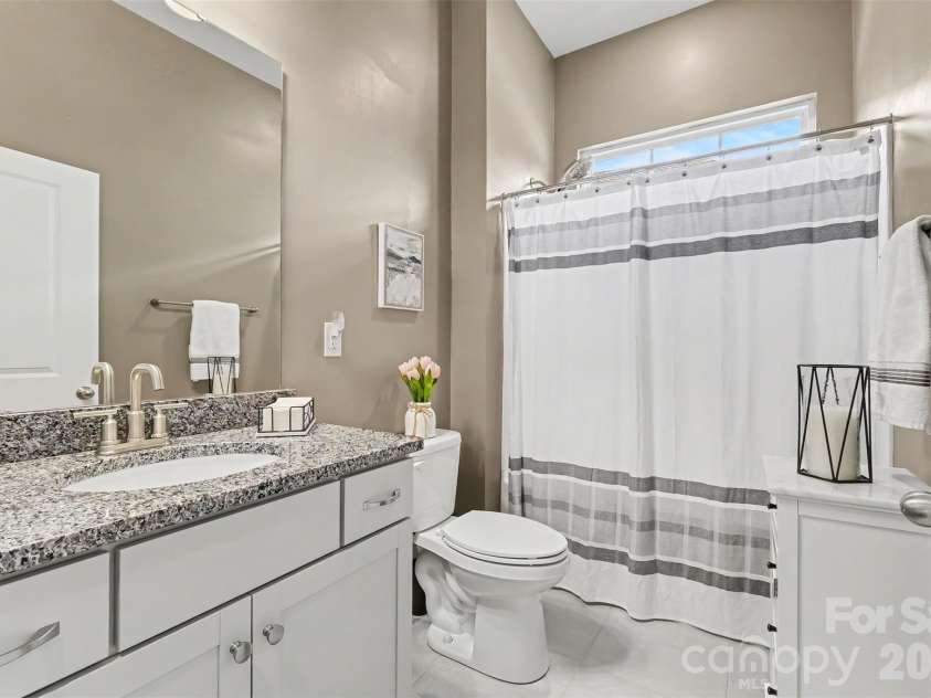 676 Latrobe Drive, Iron Station, NC 28080.  MLS# CAR4401657, YatesRealty ID 45521. Second full bath that is bright and inviting featuring a tub/shower combination and a beautiful transom window that fills the space and natural light