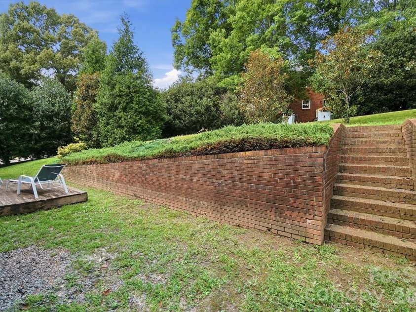 201 Wainsley Place, Matthews, NC 28105.  MLS# CAR4407896, YatesRealty ID 45535. Retaining Wall in Backyard, steps leading up to grassy area in Back Yard