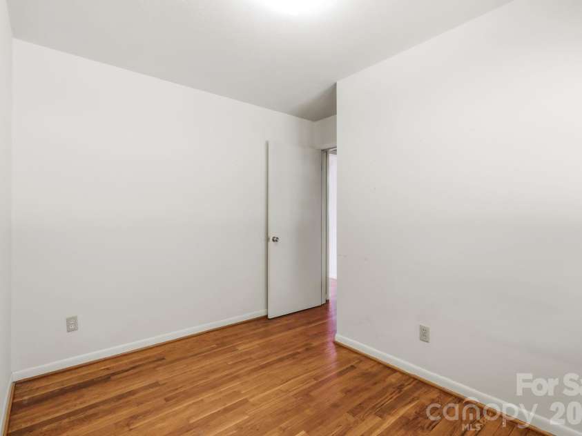 27 McGee Circle, Fairview, NC 28730.  MLS# CAR4415904, YatesRealty ID 45673. A second view highlights the hardwood flooring, neutral walls, and straightforward layout ready for personalization.