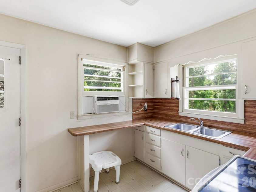 27 McGee Circle, Fairview, NC 28730.  MLS# CAR4415904, YatesRealty ID 45673. Functional kitchen features ample cabinetry, generous counter space, double-basin sink, and abundant natural light.