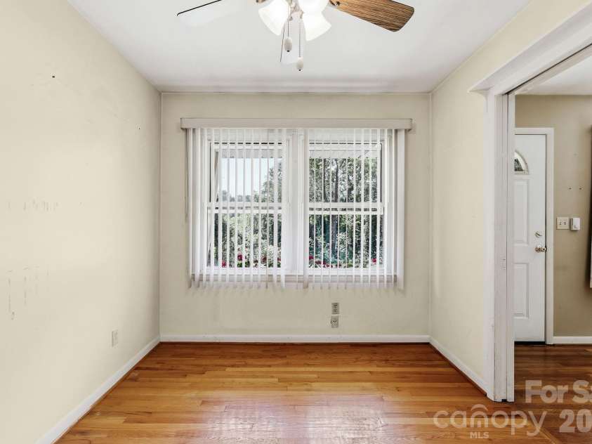 27 McGee Circle, Fairview, NC 28730.  MLS# CAR4415904, YatesRealty ID 45673. Light-filled dining space with hardwood floors, ceiling fan, and a large front-facing window.