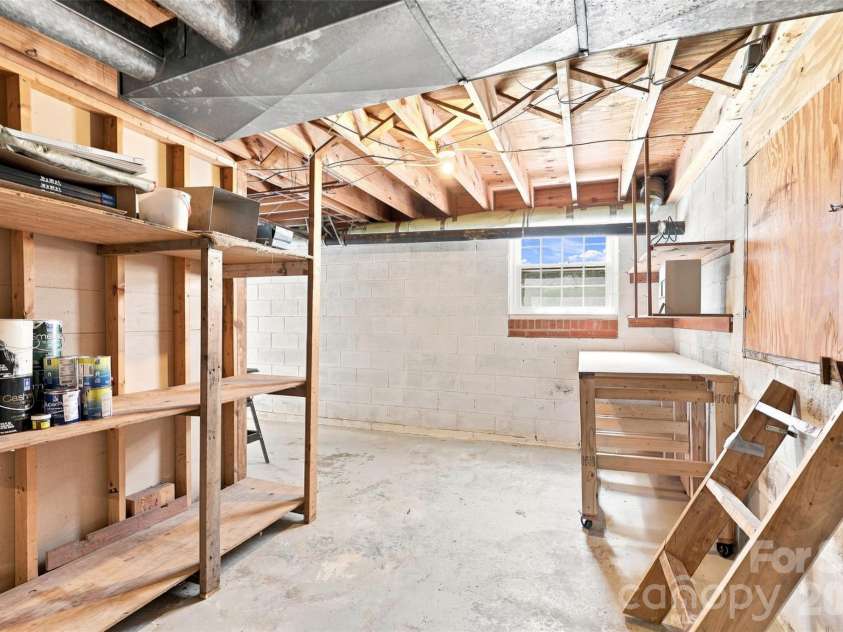 1002 Leewood Drive, Monroe, NC 28112.  MLS# CAR4416687, YatesRealty ID 45719. A workshop is located in the basement, here showing the access to the crawlspace under the kitchen