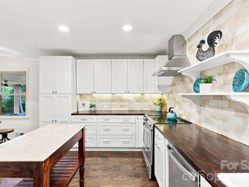 1002 Leewood Drive, Monroe, NC 28112.  MLS# CAR4416687, YatesRealty ID 45719. The kitchen island boasts a stone top for cutting and prepping