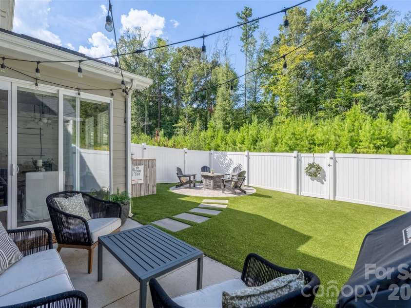 8108 Merryvale Lane, Charlotte, NC 28214.  MLS# CAR4416044, YatesRealty ID 45832. Back patio with string lights, open to the turf yard.