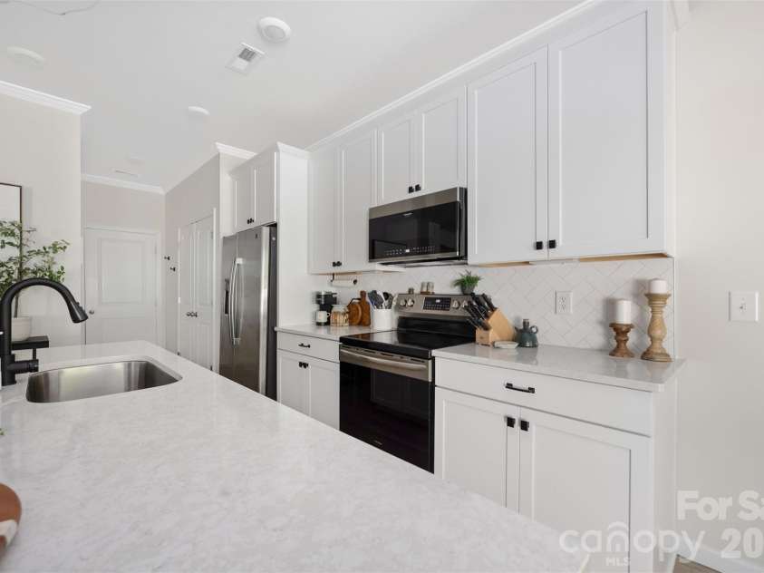 8108 Merryvale Lane, Charlotte, NC 28214.  MLS# CAR4416044, YatesRealty ID 45832. Stainless range and microwave, tile backsplash and generous counter space.