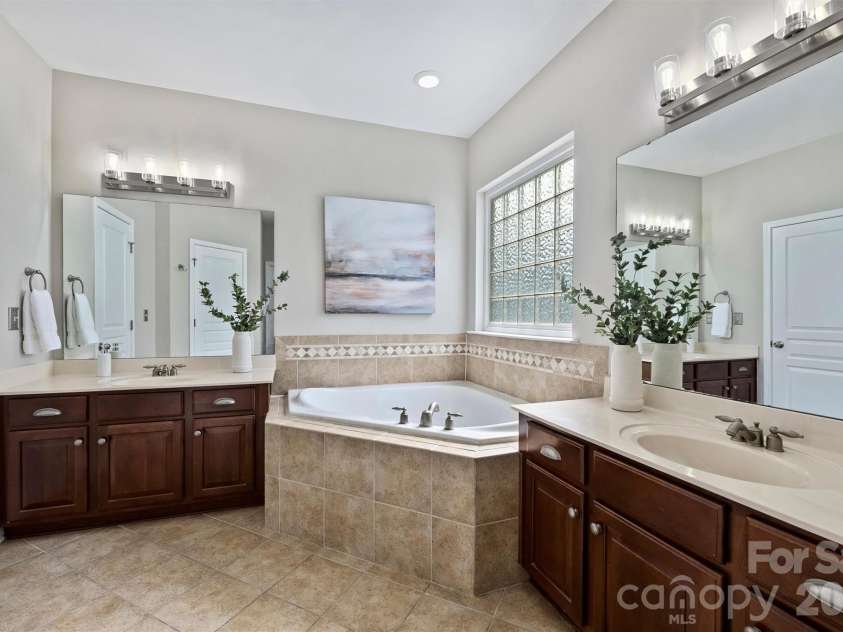 1136 Aringill Lane, Matthews, NC 28104.  MLS# CAR4415913, YatesRealty ID 45924. Large primary bath with dual vanities.