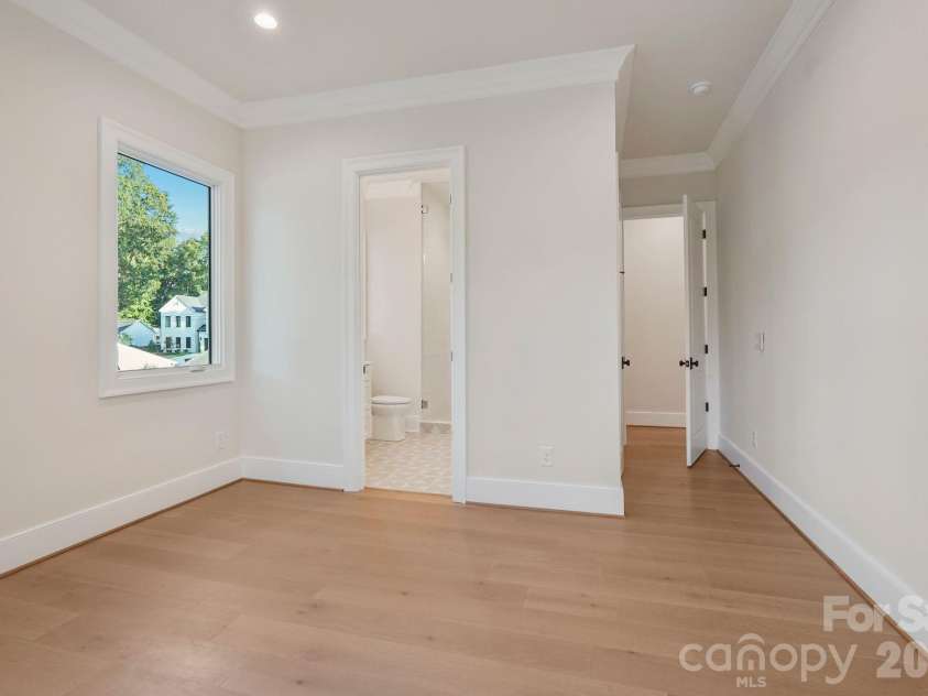 21216 Rio Oro Drive, Cornelius, NC 28031.  MLS# CAR4425303, YatesRealty ID 45943. Bedroom 3 is filled with natural light from expansive windows and features a spacious walk-in closet, combining comfort with generous storage.