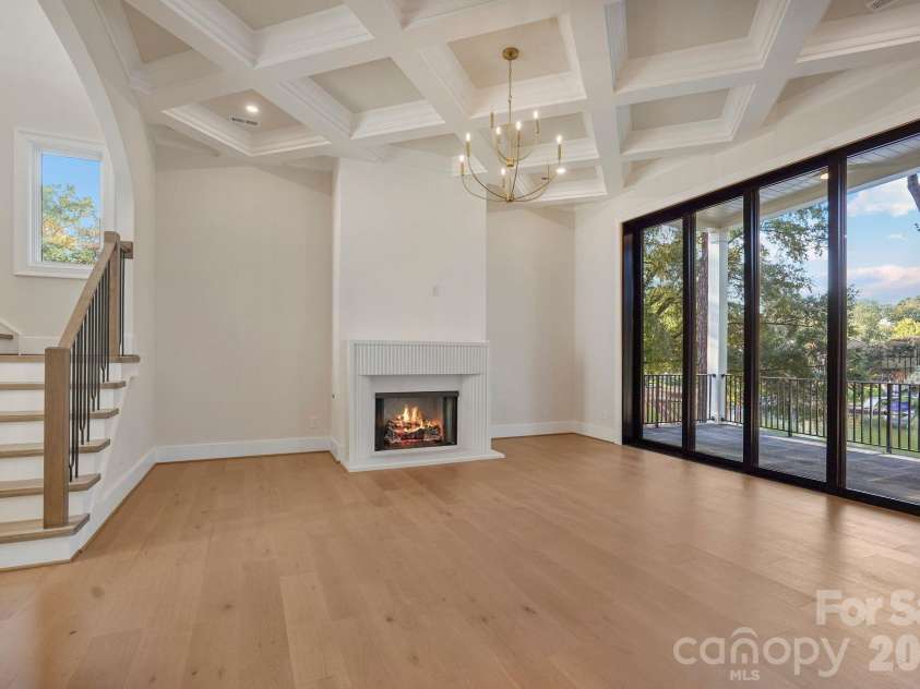 21216 Rio Oro Drive, Cornelius, NC 28031.  MLS# CAR4425303, YatesRealty ID 45943. Custom limestone fireplace surround paired with a Venetian plaster feature wall, creating a sophisticated focal point in the family room.