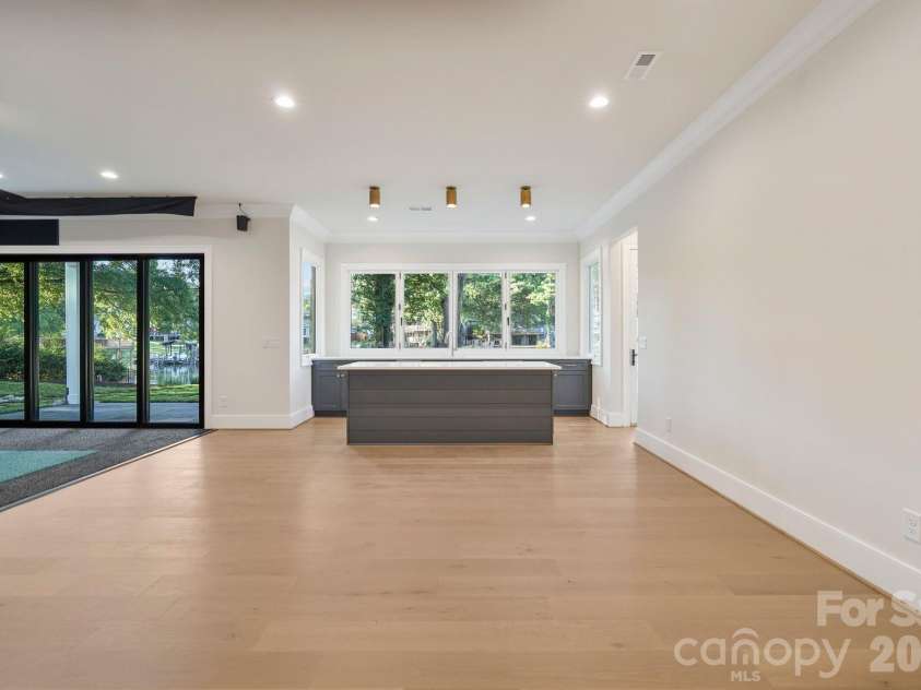 21216 Rio Oro Drive, Cornelius, NC 28031.  MLS# CAR4425303, YatesRealty ID 45943. Luxury basement kitchenette featuring a built-in wine cooler and ice maker, plus an accordion-style window that opens directly to the outdoor living space for seamless indoor-outdoor entertaining.
