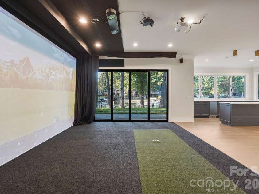 21216 Rio Oro Drive, Cornelius, NC 28031.  MLS# CAR4425303, YatesRealty ID 45943. State-of-the-art golf simulator featuring multi-sport capabilities and a 4K projection system, seamlessly transforming into a private home theater for the ultimate entertainment experience.