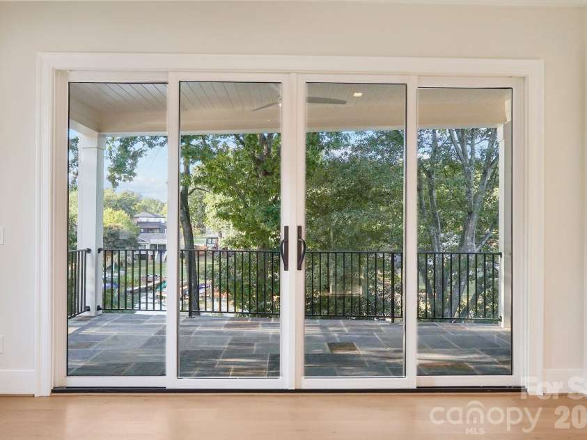 21216 Rio Oro Drive, Cornelius, NC 28031.  MLS# CAR4425303, YatesRealty ID 45943. The primary suite opens to an exclusive private balcony overlooking the water, creating a serene retreat with beautiful lake views.