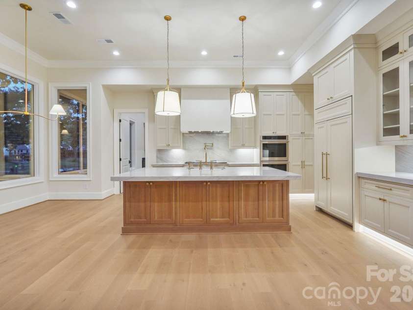 21216 Rio Oro Drive, Cornelius, NC 28031.  MLS# CAR4425303, YatesRealty ID 45943. White oak island accented by two oversized pendant lights, intentionally positioned to preserve a clean sightline to the Venetian plaster hood.
