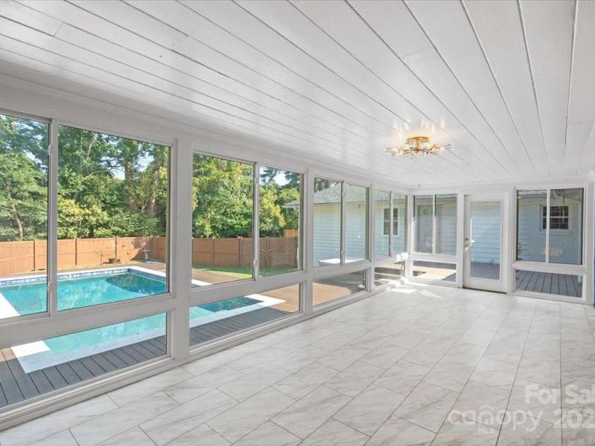 1626 Wendover Road, Charlotte, NC 28211.  MLS# CAR4155569, YatesRealty ID 4601. Enclosed sunroom with new tile flooring overlooking the outdoor pool.