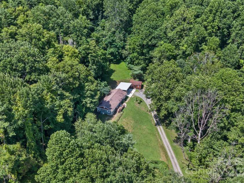 3882 New Leicester Highway, Leicester, NC 28748.  MLS# CAR4168284, YatesRealty ID 4603. Drone view of the home, surrounded by woods