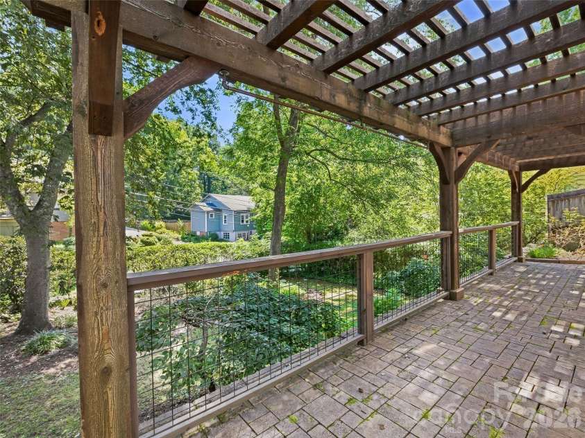53 Lyncourt Drive, Tryon, NC 28782.  MLS# CAR4417134, YatesRealty ID 46084. Back patio basement level under arbor