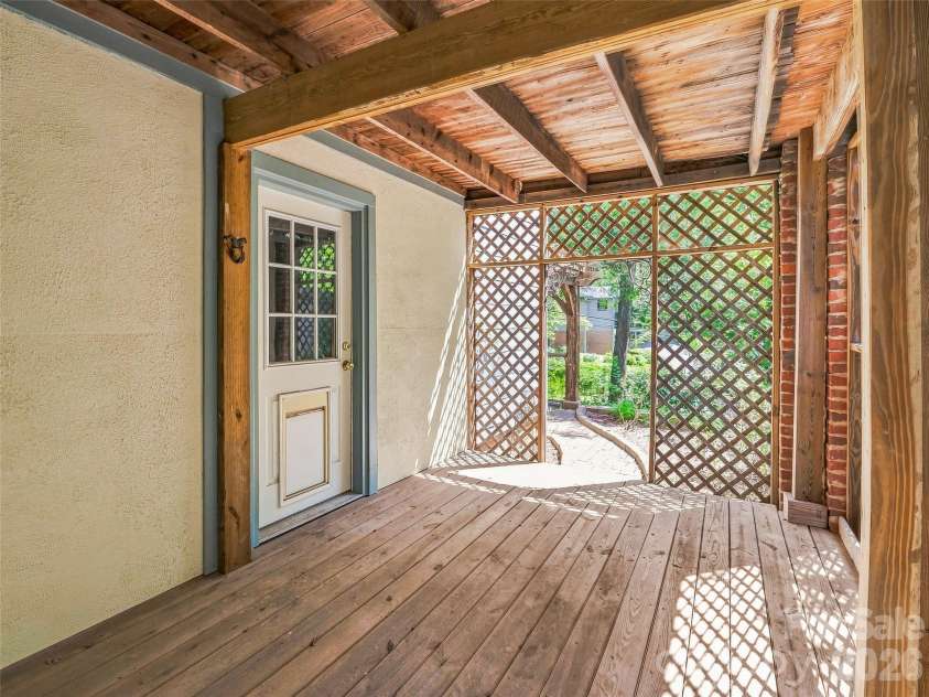 53 Lyncourt Drive, Tryon, NC 28782.  MLS# CAR4417134, YatesRealty ID 46084. Back patio basement level under arbor