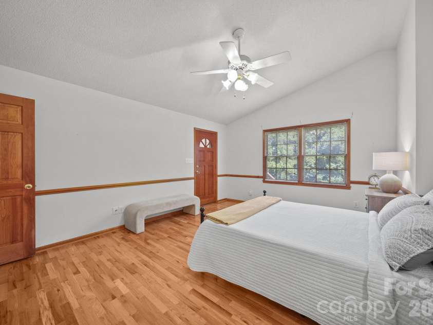 3008 Eaker Drive, Cherryville, NC 28021.  MLS# CAR4410929, YatesRealty ID 46228. The primary bedroom has a vaulted ceiling, two windows overlooking the private backyard, and a door leading to the four-season sunroom.