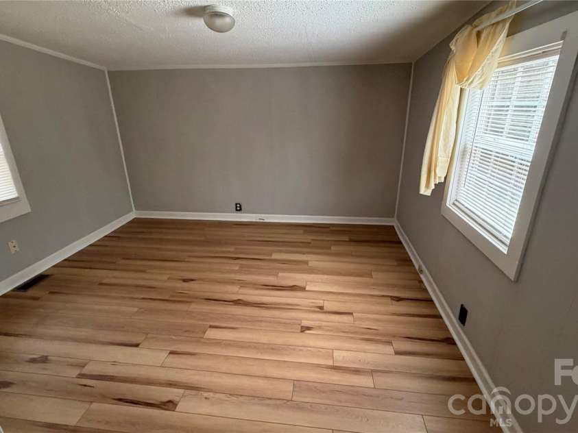 216 Auten Circle, Mount Holly, NC 28120.  MLS# CAR4416875, YatesRealty ID 46378. Back bedroom has sloping lower ceilings. New LVP flooring