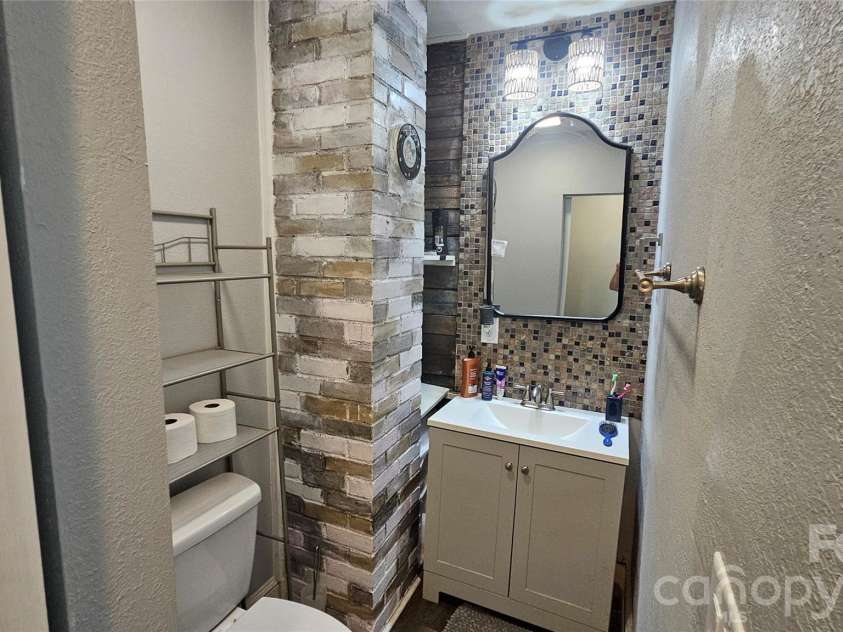 607 3rd Street, Spencer, NC 28159.  MLS# CAR4408591, YatesRealty ID 46408. Half bathroom with beautiful exposed brick