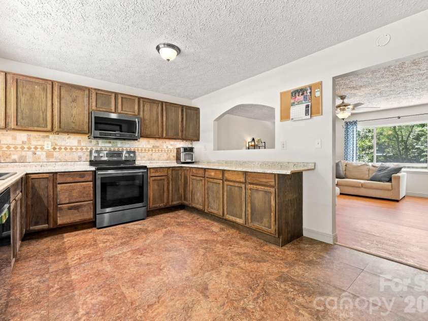 339 Indian Hills Loop, Waynesville, NC 28786.  MLS# CAR4417472, YatesRealty ID 46453. Kitchen towards living room