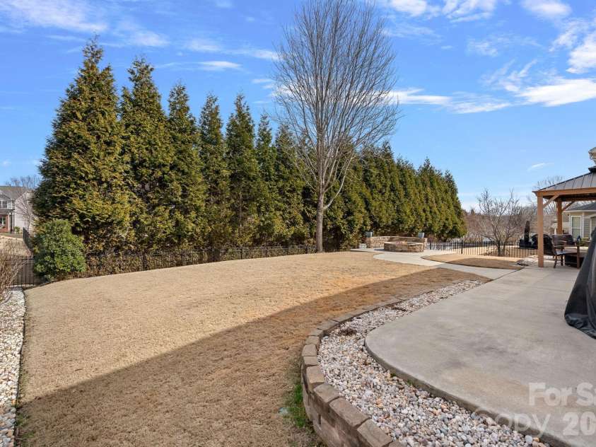 135 Rainberry Drive, Mooresville, NC 28117.  MLS# CAR4345698, YatesRealty ID 4649. Entertainer’s dream backyard featuring stunning hardscaping and ample space for family fun.