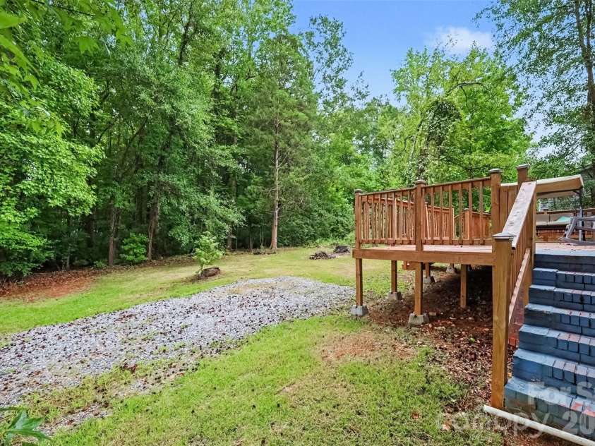 802 Stowe Drive, Lowell, NC 28098.  MLS# CAR4417684, YatesRealty ID 46559. Back deck and gravel drive