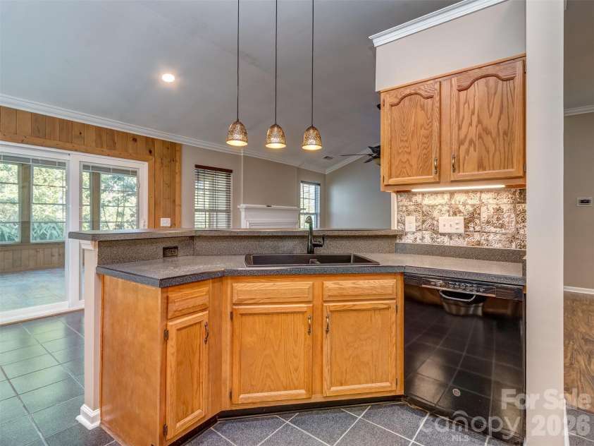 11320 Hunters Landing Drive, Charlotte, NC 28273.  MLS# CAR4426224, YatesRealty ID 46784. Lovely Kitchen with Solid Surface Countertops, Pendant Lighting, Custom Backsplash, Tile Flooring, Crown Molding, Recessed and Under Cabinet Lighting, & Eat At Bar that is perfect for Entertaining!