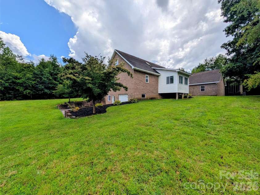 213 Rustling Pines Drive, Hendersonville, NC 28792.  MLS# CAR4418354, YatesRealty ID 46806. Side View of home and beautiful Green Space!