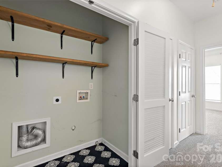 7600 Turley Ridge Lane, Charlotte, NC 28273.  MLS# CAR4413385, YatesRealty ID 46876. Full size laundry space with open shelving and several closets in third floor hallway.