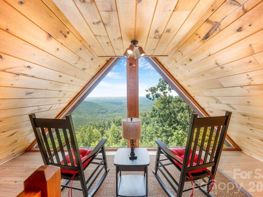 175 Big Rock Road, Bostic, NC 28018.  MLS# CAR4416989, YatesRealty ID 46907. Cozy upstairs loft framed by dramatic A-frame windows, creating the perfect quiet retreat to relax and take in the spectacular long-range mountain views.
