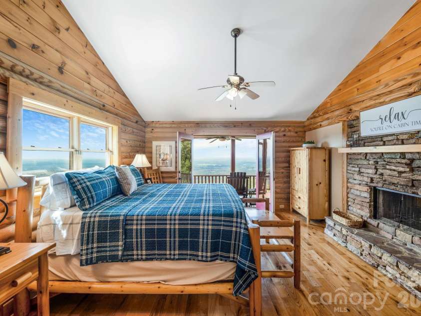 175 Big Rock Road, Bostic, NC 28018.  MLS# CAR4416989, YatesRealty ID 46907. Spacious primary suite features a dramatic double-sided stacked-stone fireplace and French doors opening directly to the front porch, where breathtaking long-range mountain views extend up to 60 miles.