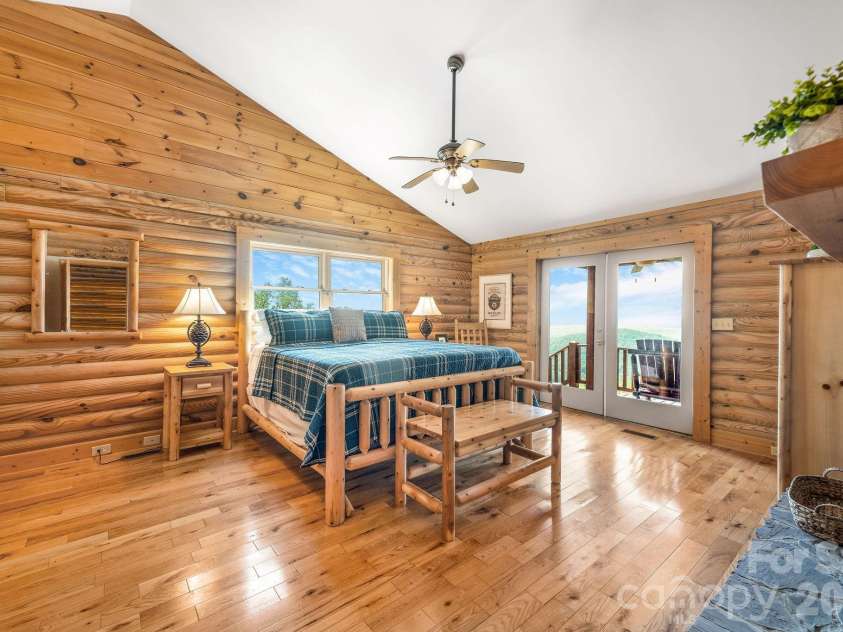 175 Big Rock Road, Bostic, NC 28018.  MLS# CAR4416989, YatesRealty ID 46907. Spacious primary suite features a dramatic double-sided stacked-stone fireplace and French doors opening directly to the front porch, where breathtaking long-range mountain views extend up to 60 miles.