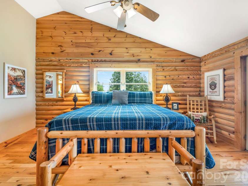 175 Big Rock Road, Bostic, NC 28018.  MLS# CAR4416989, YatesRealty ID 46907. Spacious primary suite features a dramatic double-sided stacked-stone fireplace and French doors opening directly to the front porch, where breathtaking long-range mountain views extend up to 60 miles.