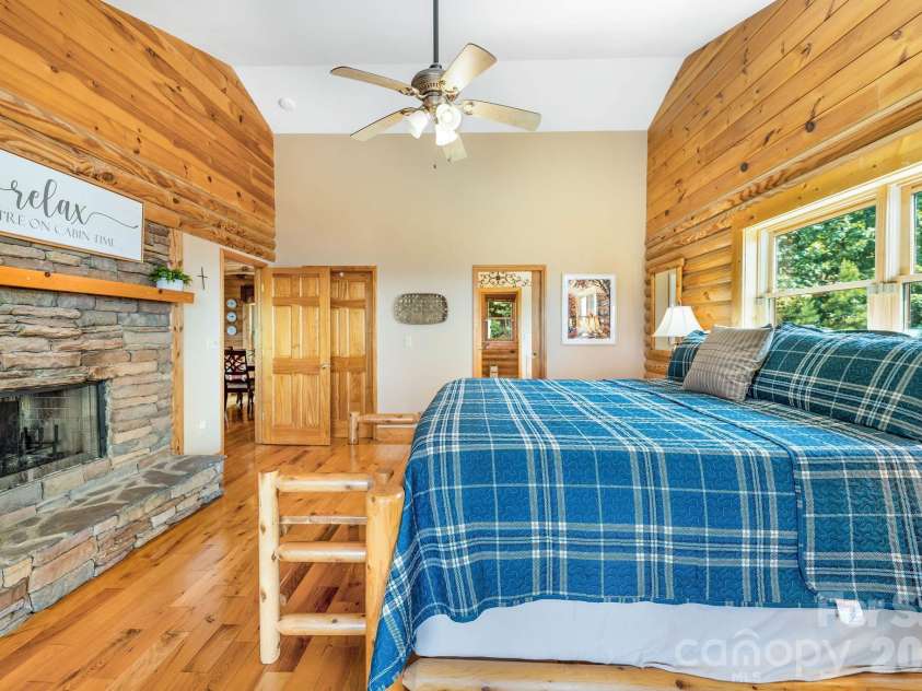 175 Big Rock Road, Bostic, NC 28018.  MLS# CAR4416989, YatesRealty ID 46907. Spacious primary suite features a dramatic double-sided stacked-stone fireplace and French doors opening directly to the front porch, where breathtaking long-range mountain views extend up to 60 miles.