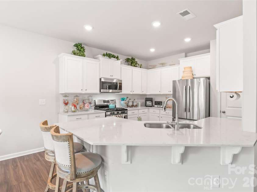 15308 Lake Ridge Road, Charlotte, NC 28278.  MLS# CAR4402264, YatesRealty ID 46930. Bright, gorgeous kitchen with seating at the breakfast bar, gorgeous Quartz counters, tile backsplash, stainless steel appliances with gas stove