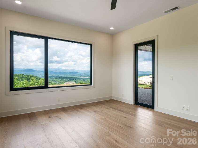 24 Watchman Drive, Hendersonville, NC 28791.  MLS# CAR4215455, YatesRealty ID 4699. Primary Bedroom with XL windows showcasing layered mountain views