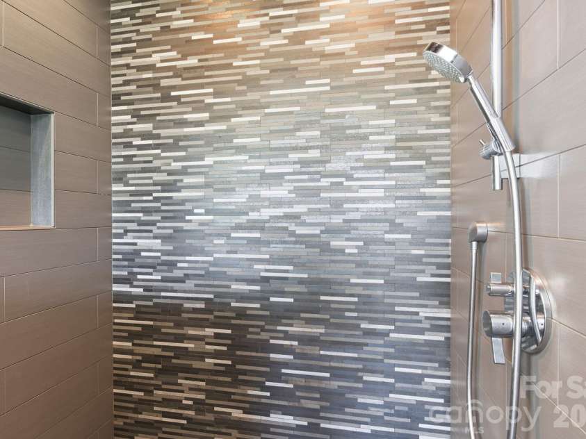 31 Bradford Vistas Drive, Fletcher, NC 28732.  MLS# CAR4303470, YatesRealty ID 4703. Artfully tiled standup shower in primary bathroom suite