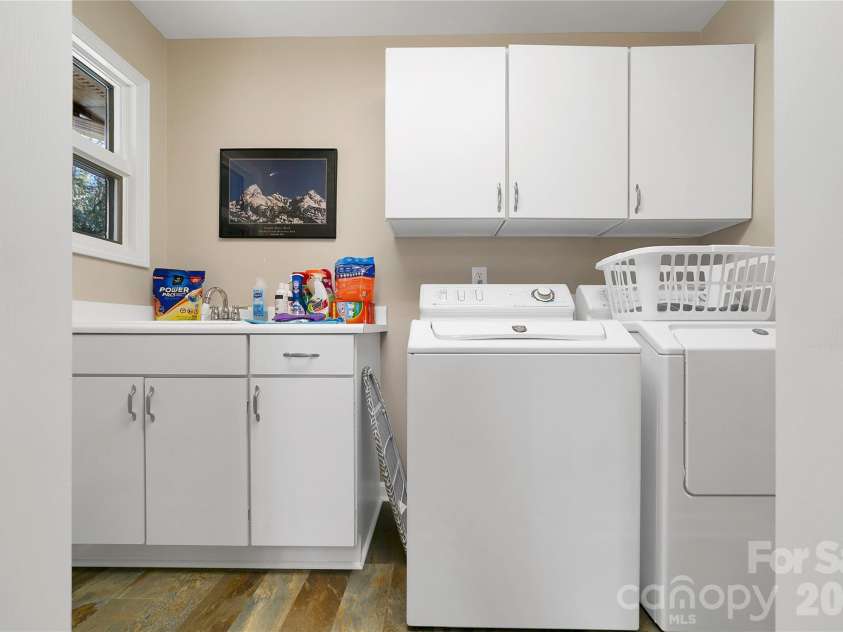 59 Agaliha Lane, Brevard, NC 28712.  MLS# CAR4338161, YatesRealty ID 4724. Even though it is behind closet doors, you can walk into this laundry area and have a sink and plenty of cabinet space.