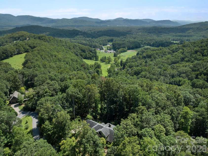 36 Windsong Drive, Fairview, NC 28730.  MLS# CAR4418309, YatesRealty ID 47314. Subject property backs up to a 60 acres parcel.