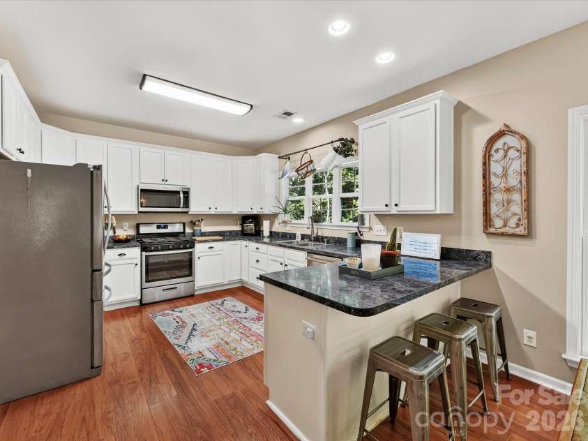 150 Cavendish Drive, Mooresville, NC 28115.  MLS# CAR4416863, YatesRealty ID 47420. Bright, functional kitchen featuring crisp white cabinetry, stainless steel appliances, abundant counter space, a breakfast bar with seating, and an open connection to the dining and Great Room.