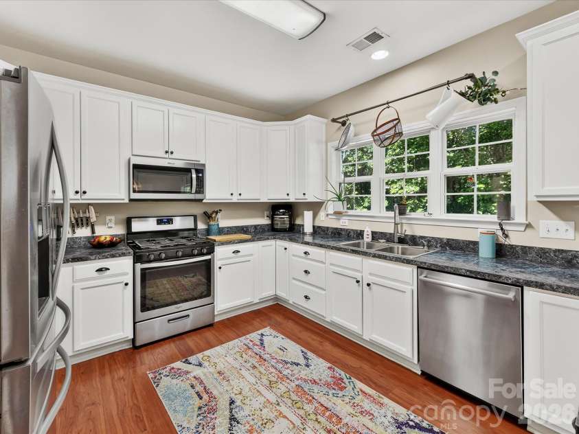 150 Cavendish Drive, Mooresville, NC 28115.  MLS# CAR4416863, YatesRealty ID 47420. Bright, functional kitchen featuring crisp white cabinetry, stainless steel appliances, abundant counter space, a breakfast bar with seating, and an open connection to the dining and Great Room.