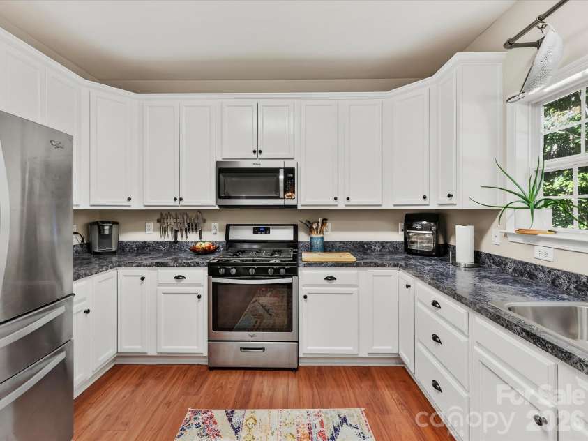 150 Cavendish Drive, Mooresville, NC 28115.  MLS# CAR4416863, YatesRealty ID 47420. Bright, functional kitchen featuring crisp white cabinetry, stainless steel appliances, abundant counter space, a breakfast bar with seating, and an open connection to the dining and Great Room.