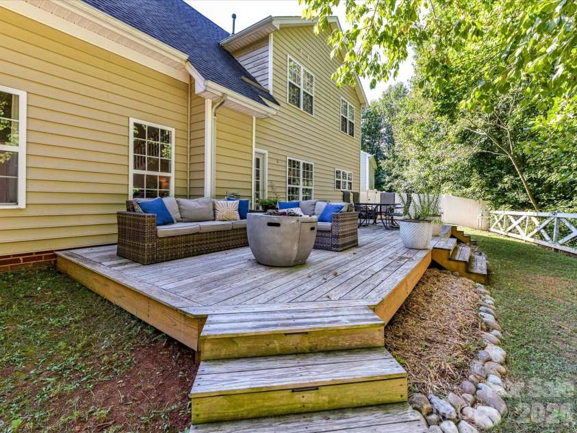 150 Cavendish Drive, Mooresville, NC 28115.  MLS# CAR4416863, YatesRealty ID 47420. Expansive back deck offering multiple areas for dining and relaxing while overlooking the fenced, tree-lined backyard.