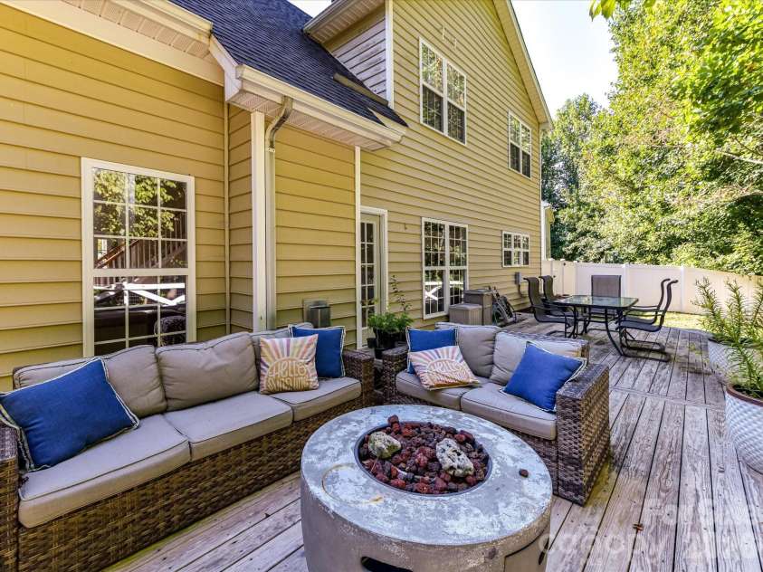 150 Cavendish Drive, Mooresville, NC 28115.  MLS# CAR4416863, YatesRealty ID 47420. Expansive back deck offering multiple areas for dining and relaxing while overlooking the fenced, tree-lined backyard.