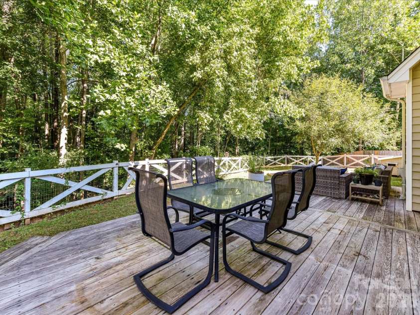 150 Cavendish Drive, Mooresville, NC 28115.  MLS# CAR4416863, YatesRealty ID 47420. Expansive back deck offering multiple areas for dining and relaxing while overlooking the fenced, tree-lined backyard.