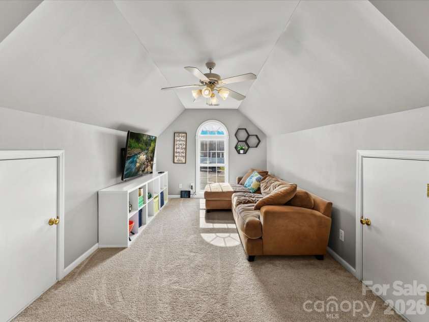 150 Cavendish Drive, Mooresville, NC 28115.  MLS# CAR4416863, YatesRealty ID 47420. Spacious bonus room featuring a vaulted ceiling, soft carpeting, abundant natural light, and flexible space for a media room, playroom, or additional living area.