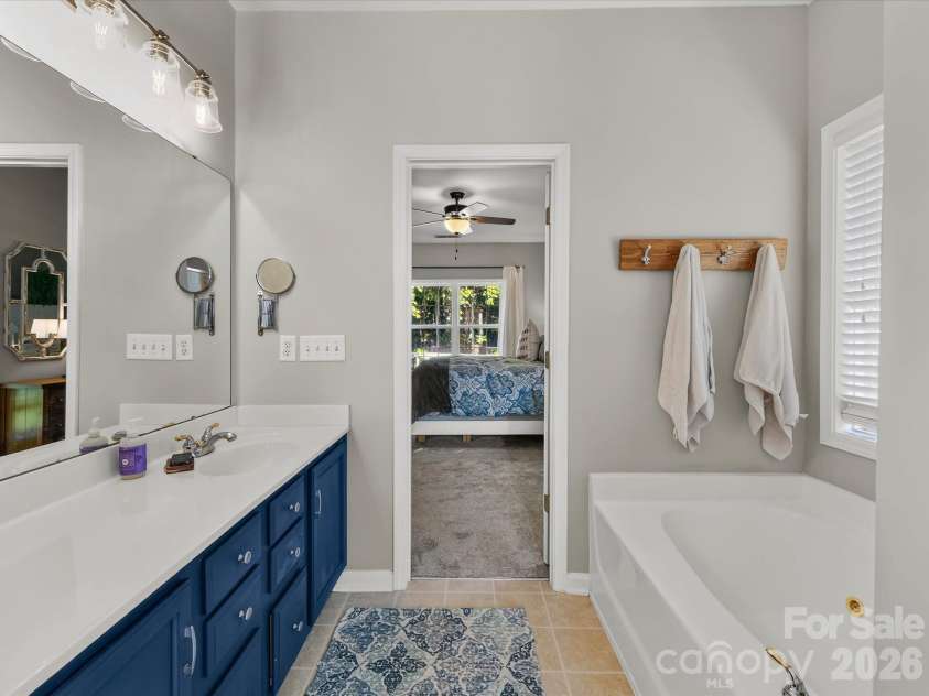 150 Cavendish Drive, Mooresville, NC 28115.  MLS# CAR4416863, YatesRealty ID 47420. Spacious Primary Bath featuring a jetted soaking tub, separate walk-in shower, generous vanity space, built-in shelving, and abundant natural light.