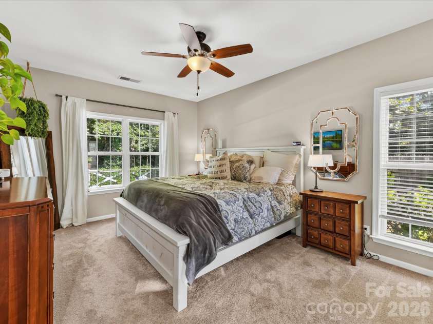 150 Cavendish Drive, Mooresville, NC 28115.  MLS# CAR4416863, YatesRealty ID 47420. Spacious Primary Suite featuring abundant natural light, neutral finishes, plush carpeting, a ceiling fan, and convenient access to the ensuite bath.