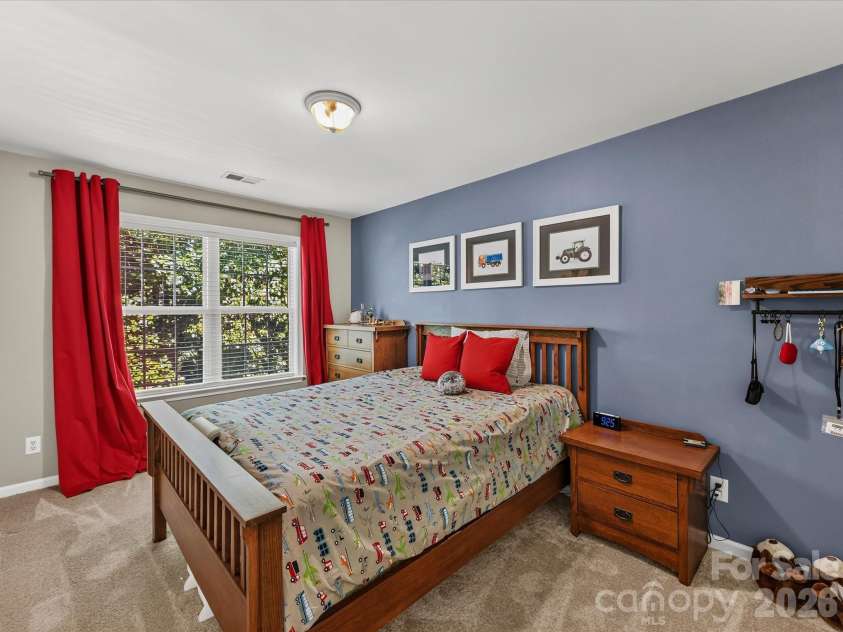 150 Cavendish Drive, Mooresville, NC 28115.  MLS# CAR4416863, YatesRealty ID 47420. Spacious secondary bedroom featuring soft carpeting, a large window with abundant natural light, and a generous closet for storage.