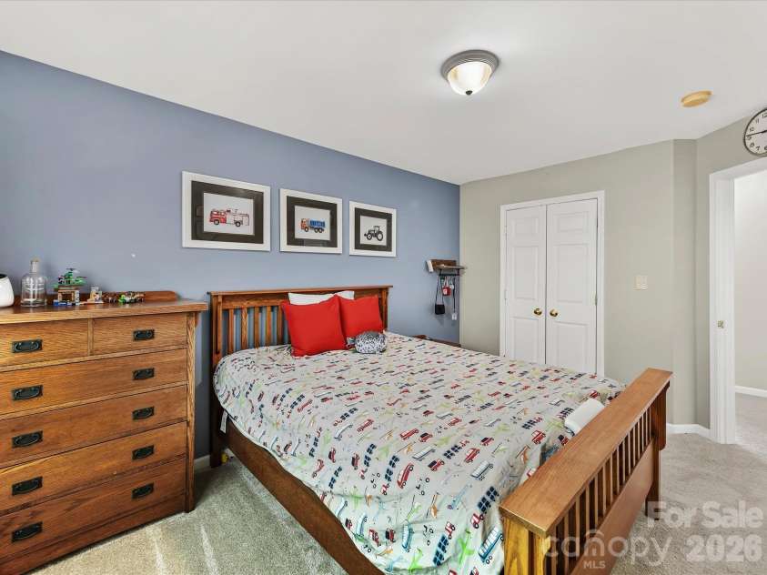 150 Cavendish Drive, Mooresville, NC 28115.  MLS# CAR4416863, YatesRealty ID 47420. Spacious secondary bedroom featuring soft carpeting, a large window with abundant natural light, and a generous closet for storage.